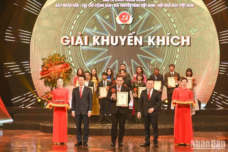 Tổng Biên tập Báo Nhân Dân Lê Quốc Minh và Bộ trưởng Thông tin Truyền thông Nguyễn Mạnh Hùng trao Giải Khuyến khích cho các tác giả.