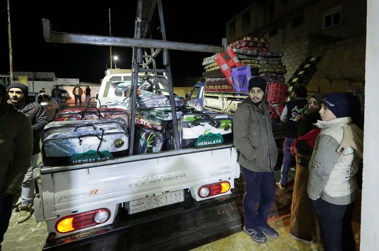 Xe tải chở chăn nệm đỗ bên ngoài một trung tâm thể thao, nơi được sử dụng làm địa điểm tạm trú của những người phải di dời do động đất, tại Azaz, Syria. (Ảnh: Reuters)