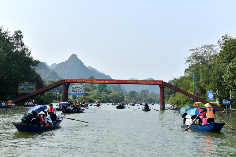 Khách hành hương đi xuồng đò qua cầu Hội để vào chùa Hương. Khách hành hương đi xuồng đò qua cầu Hội để vào chùa Hương.