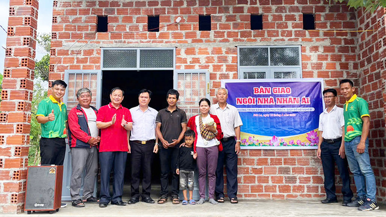 Chủ tịch Ủy ban nhân dân huyện Đăk Hà Hà Tiến (thứ 3 từ trái sang) bàn giao ngôi nhà nhân ái cho gia đình hộ nghèo A Rô và Y Ran.