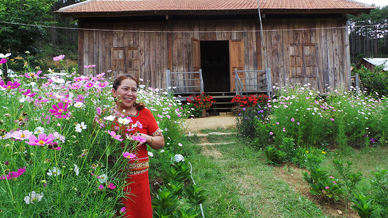 Chị Y Lim bên ngôi nhà được sử dụng làm homestay của mình. Chị Y Lim bên ngôi nhà được sử dụng làm homestay của mình.