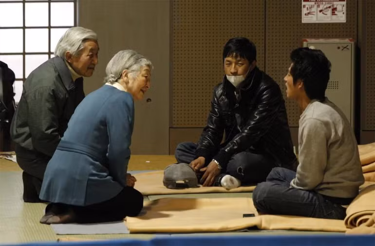 Nhật hoàng Akihito và Hoàng hậu Michiko trò chuyện với những người sơ tán tại nhà thi đấu Budokan ở Tokyo, địa điểm được sử dụng làm nơi lánh nạn cho những người phải di dời do thảm họa, ngày 30/3/2011. (Ảnh: Reuters)