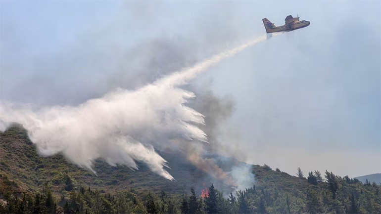May bay cứu hỏa thả nước xuống đám cháy gần làng Vati, đảo Rhodes, Hy Lạp, ngày 25/7/2023. (Ảnh: Reuters) May bay cứu hỏa thả nước xuống đám cháy gần làng Vati, đảo Rhodes, Hy Lạp, ngày 25/7/2023. (Ảnh: Reuters)