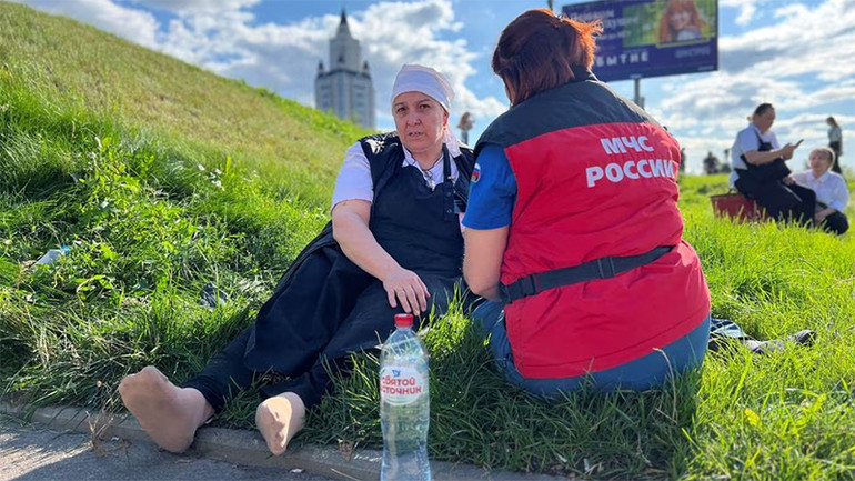 Nhân viên của Bộ Tình trạng Khẩn cấp của Nga hỗ trợ y tế cho người phụ nữ sau sự cố tại trung tâm thương mại Vremena Goda (The Seasons). (Ảnh: Reuters)