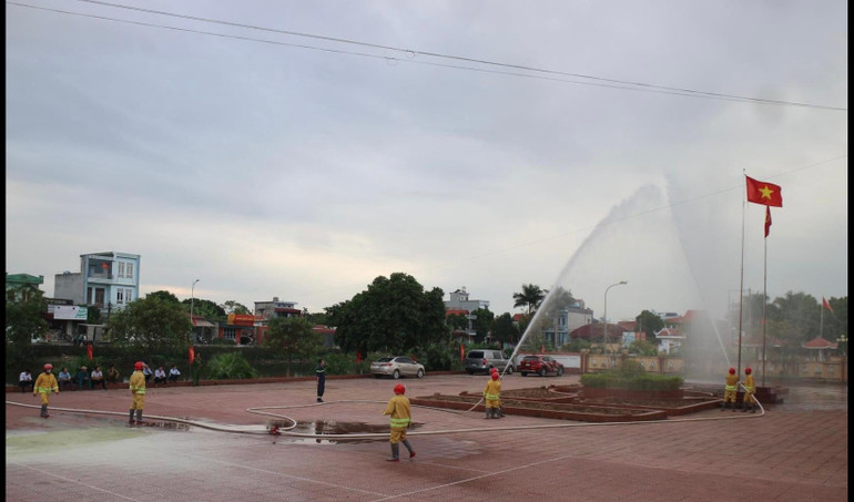 Các thành viên Tổ tự quản thực hành phun nước chữa đám cháy trên cao.