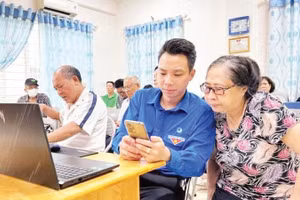 Đoàn viên phường Tây Hồ hướng dẫn người dân các thao tác thực hiện thủ tục hành chính trên điện thoại di động.