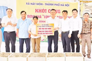 Bí thư Đảng ủy xã Hát Môn trao tiền hỗ trợ người dân xây dựng nhà ở.