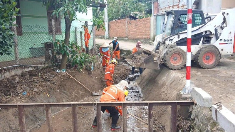 Công nhân bảo dưỡng đường bộ hót dọn cống thực hiện công việc bảo dưỡng thường xuyên.