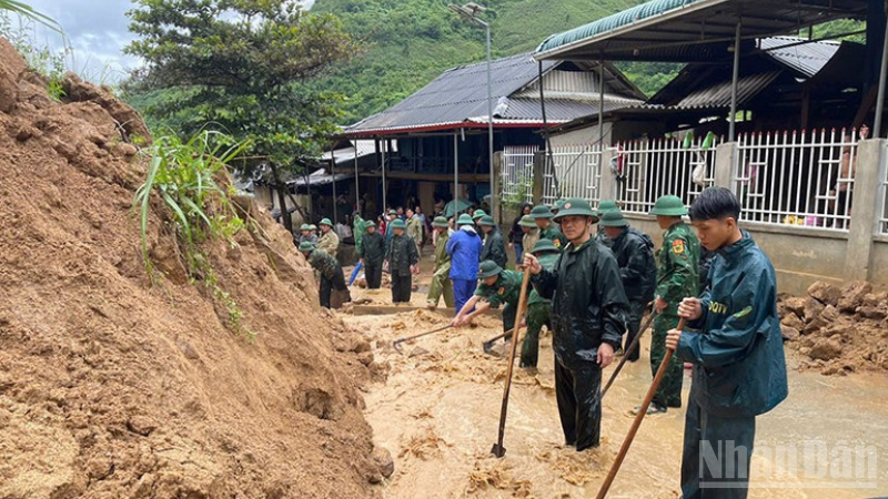Bộ đội Biên phòng vùng thượng du Thanh Hóa xử lý đất, đá sạt từ ta luy xuống đường dân sinh. (Ảnh: Báo Nhân Dân)