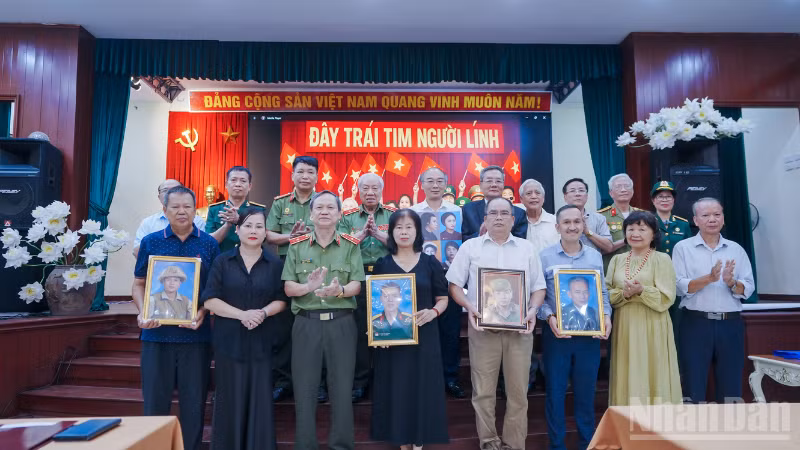 Đại diện các gia đình đón nhận di ảnh anh hùng liệt sĩ tại sự kiện. 