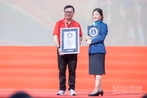 Đồng chí Lê Quốc Minh, Ủy viên Trung ương Đảng, Tổng Biên tập Báo Nhân Dân, Phó Trưởng ban Tuyên giáo Trung ương, Chủ tịch Hội Nhà báo Việt Nam thay mặt Ban tổ chức nhận chứng nhận Kỷ lục Guinness thế giới. (Ảnh: MINH DUY)