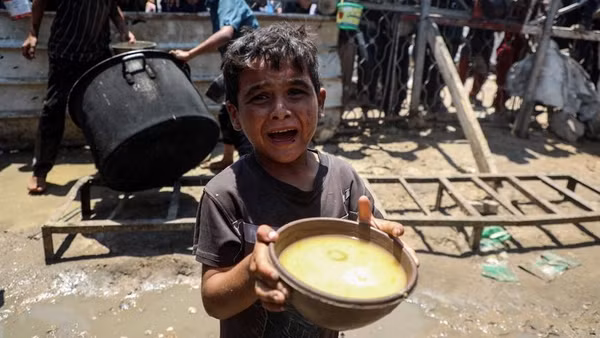 Một em bé Palestine nhận thức ăn miễn phí từ bếp ăn từ thiện ở thành phố Gaza, ngày 24/7/2025. (Ảnh: Tân Hoa Xã)