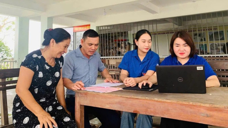 Государственные служащие и члены молодежного союза в коммуне Камбинь провинции Хатинь помогают жителям заполнять онлайн-заявки. z7330976072879-746a6a4b611c0c37ba9741a0f56c6c43-9528.jpg