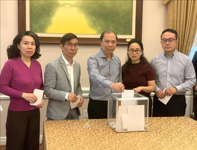 Đại sứ Việt Nam tại Mỹ Nguyễn Quốc Dũng (giữa) quyên góp ủng hộ đồng bào bị bão lụt trong nước. (Ảnh: Ngọc Quang/ PV TTXVN tại Mỹ)