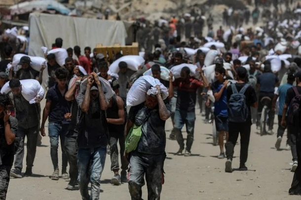 Người dân Palestine nhận hàng viện trợ nhân đạo tại Beit Lahia, phía Bắc Dải Gaza, ngày 1/8/2025. (Ảnh: THX/TTXVN)