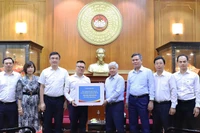 Đồng chí Đỗ Văn Chiến (thứ 4 từ phải sang) tiếp nhận số tiền ủng hộ từ tập thể lãnh đạo, cán bộ, người lao động Báo Nhân Dân.