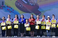 Bí thư Trung ương Đoàn, Chủ tịch Hội đồng Đội Trung ương Nguyễn Phạm Duy Trang (thứ 5 từ trái sang) cùng đại diện Ban tổ chức Ngày hội trao học bổng tặng thiếu nhi vượt khó học tốt.