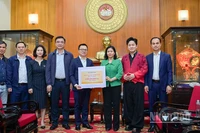 Tổng Biên tập Báo Nhân Dân Lê Quốc Minh trao kinh phí ủng hộ đồng bào khắc phục hậu quả bão, lũ. (Ảnh: BẢO LONG)