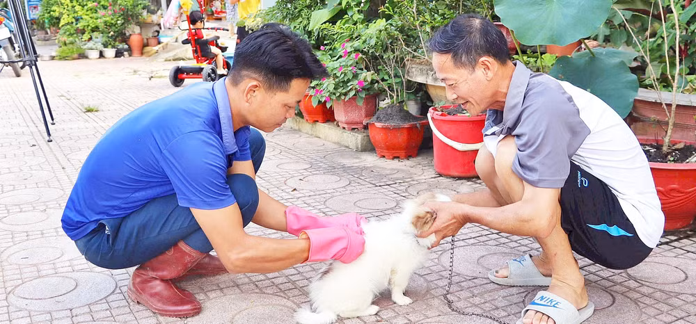 Cán bộ Trung tâm Dịch vụ nông nghiệp huyện Điện Biên Đông đến từng gia đình để tiêm vắc-xin phòng bệnh dại cho chó, mèo.
