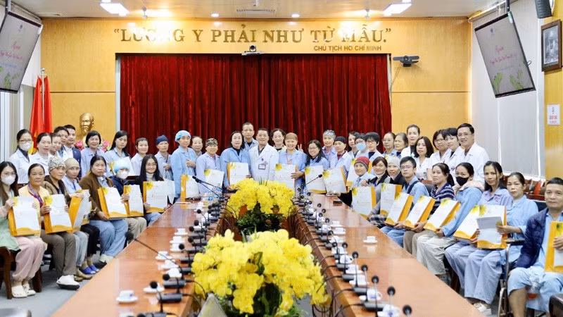 Lãnh đạo Bệnh viện K, các y, bác sĩ chụp ảnh lưu niệm với những người bệnh tại buổi gặp mặt.