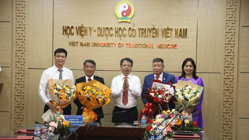 Phó Giáo sư, Tiến sĩ Nguyễn Quốc Huy, Giám đốc Học viện Y-Dược học cổ truyền Việt Nam trao Quyết định và tặng hoa cho các Phó Giáo sư tại buổi lễ.