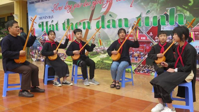 Thầy giáo Phùng Văn Thời, Phó Hiệu trưởng Trường dân tộc nội trú Trung học cơ sở huyện Văn Quan (Lạng Sơn), người ngoài cùng bên trái, đang hướng dẫn các em học sinh sử dụng đàn tính trong hoạt động giáo dục ngoài giờ lên lớp.