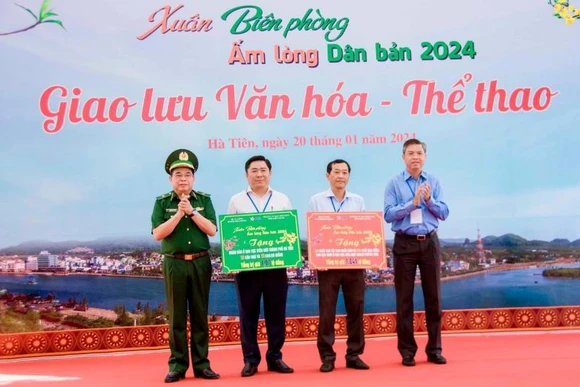 Thiếu tướng Phùng Quốc Tuấn, Phó Chính ủy Bộ đội biên phòng và Phó Chủ tịch Ủy ban Nhân dân tỉnh Kiên Giang Nguyễn Lưu Trung (bên phải) trao biển tượng trưng tặng hiện vật tặng nhân dân, học sinh khu vực biên giới thành phố Hà Tiên, trị giá hơn 2,1 tỉ đồng. Ảnh: Đăng Bảy