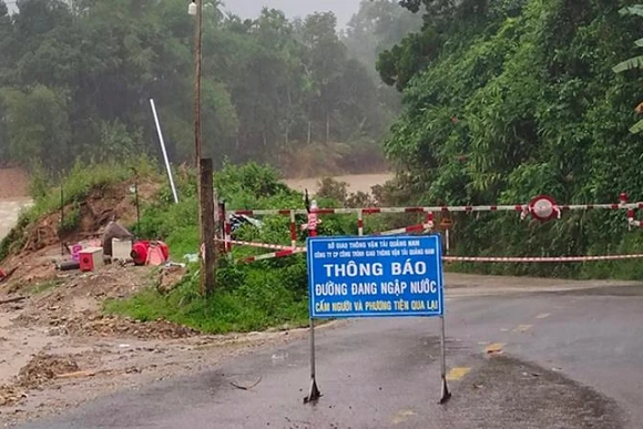 Cắm biển báo và giăng dây cấm người qua lại điểm ngập nước trên tuyến 14B, đoạn qua xã Trà Tân.