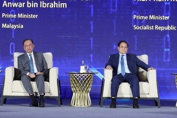 Thủ tướng Phạm Minh Chính và Thủ tướng Malaysia Anwar Ibrahim tham dự phiên thảo luận. (Ảnh: TTXVN)