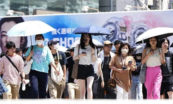 Người dân Tokyo (Nhật Bản) di chuyển dưới trời nắng nóng, ngày 27/7/2023. (Ảnh: Kyodo/TTXVN)