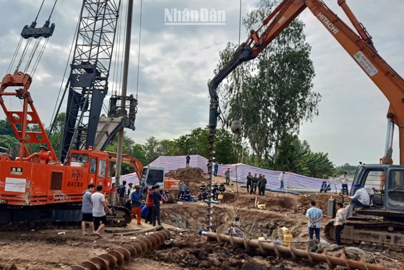 Lực lượng cứu nạn, cứu hộ tìm cách đưa bé Hạo Nam ra khỏi trụ bê-tông. (Ảnh: HỮU NGHĨA)