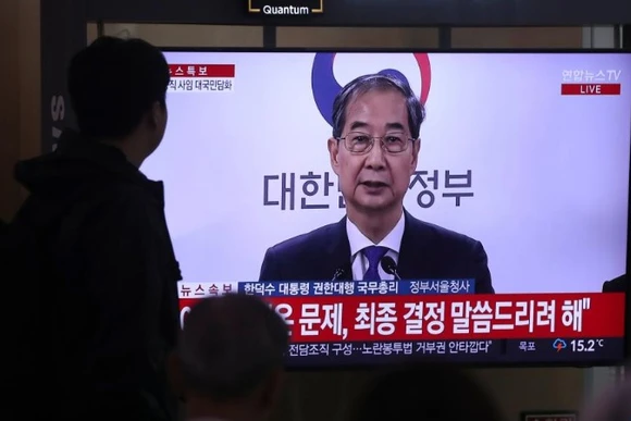 Người dân theo dõi bài phát biểu của ông Han Duck Soo tại ga tàu Seoul, ngày 1/5/2025. (Ảnh: Xinhua)