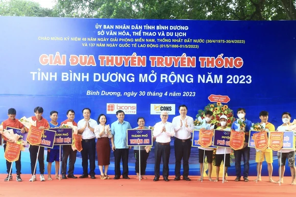 Bí thư Tỉnh ủy Bình Dương Nguyễn Văn Lợi và các đại biểu trao cờ lưu niệm và hoa cho các đội tham dự Giải đua thuyền.