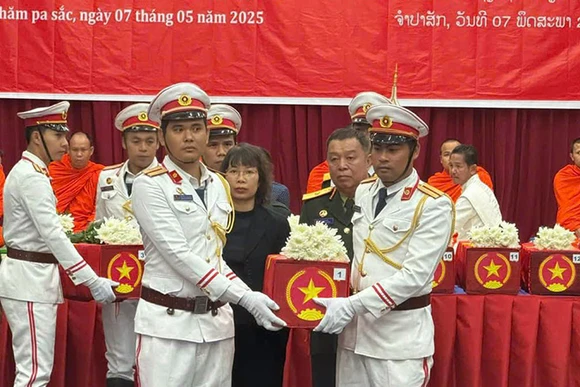 Các đại biểu thực hiện nghi lễ tiễn đưa hài cốt các liệt sĩ về nước. (Ảnh: HẢI TIẾN)