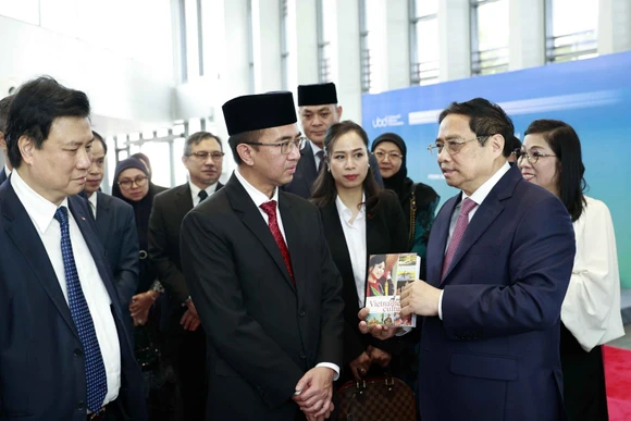 Thủ tướng Phạm Minh Chính xem trưng bày sách tiếng Việt tại Trường đại học Quốc gia Brunei. (Ảnh TTXVN)