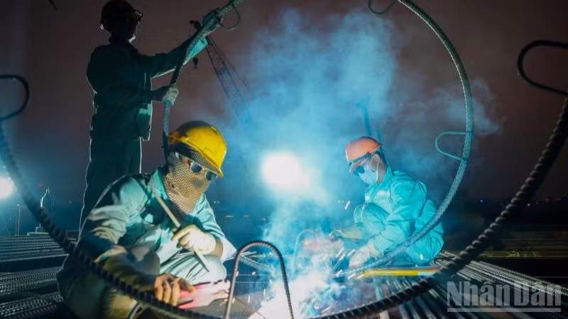 Những ngày cận Tết Nguyên đán, ngày cũng như đêm, trên công trường xây dựng cầu Trần Hưng Đạo (Hà Nội), nhịp độ lao động vẫn hết sức sôi động, khẩn trương.