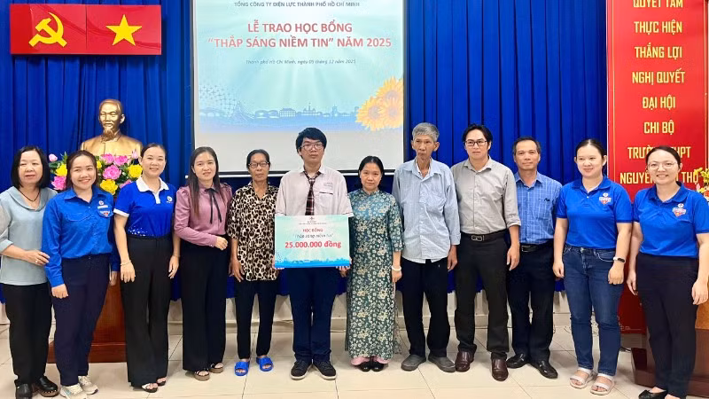 Đại diện EVNHCMC và các đơn vị trao học bổng "Thắp sáng niềm tin" đến em Nguyễn Đỗ Kim Long.