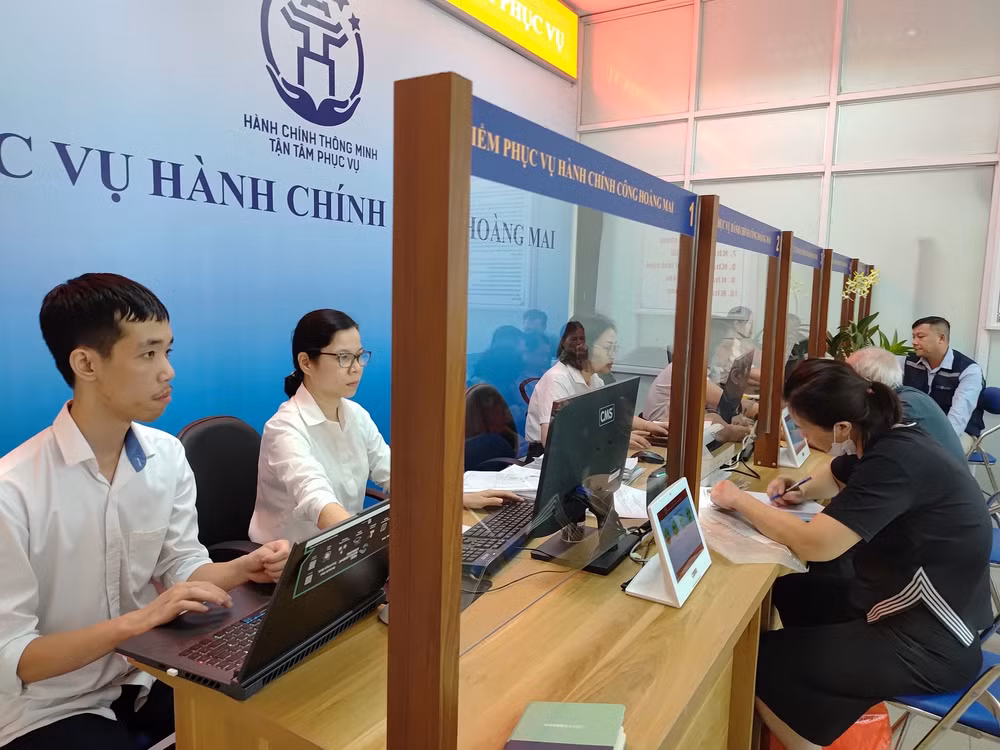 Điểm phục vụ hành chính công Hoàng Mai (Hà Nội), các chuyên viên nhiệt tình hướng dẫn người dân làm thủ tục. (Ảnh HẢI MIÊN)