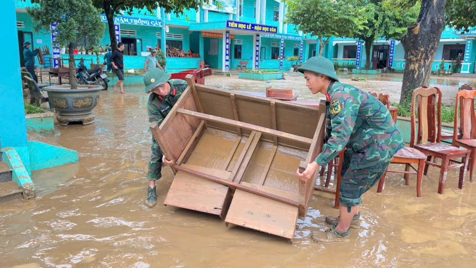Officieren en soldaten van het K55 Technisch Magazijn helpen de Hoang Dieu basisschool (gemeente Nong Son) met het schoonmaken van tafels en stoelen. 10.jpg