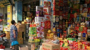 Người dân mua bánh, kẹo tại cửa hàng trên phố Hàng Giấy, Hà Nội. (Ảnh TUỆ NGHI)