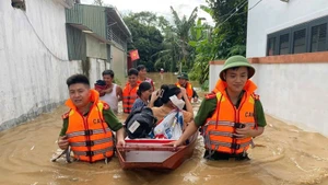 Công an xã Anh Sơn (Nghệ An) phối hợp lực lượng chức năng dùng thuyền hỗ trợ người dân khỏi các khu vực sạt lở, nguy cơ ngập cao. (Ảnh: ANH VŨ)
