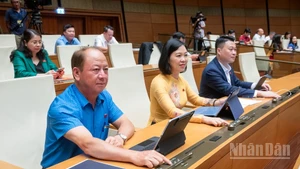 Đại biểu Quốc hội bấm nút thông qua Luật sửa đổi, bổ sung một số điều của Luật Tổ chức Tòa án nhân dân. (Ảnh: DUY LINH)