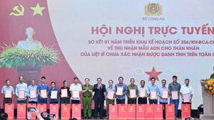 Thủ tướng Chính phủ Phạm Minh Chính trao Thông báo kết quả giám định ADN hài cốt liệt sĩ cho đại diện thân nhân các gia đình liệt sĩ. (Ảnh: TRẦN HẢI) 