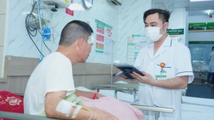 Nhân viên y tế Bệnh viện Bạch Mai sử dụng bệnh án điện tử trong quá trình thăm khám cho bệnh nhân.