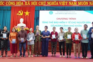 Phó Giám đốc Bảo hiểm xã hội tỉnh Trần Ngọc Tuấn cùng các đại biểu trao tặng thẻ bảo hiểm y tế cho người dân. (Ảnh: BTC)
