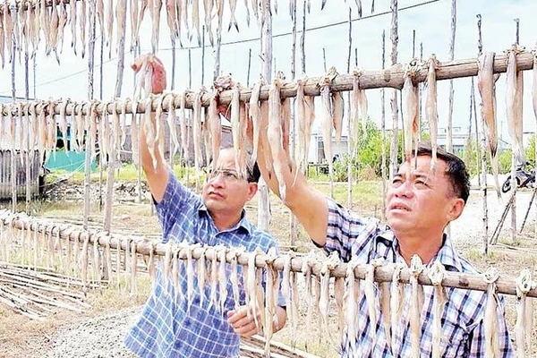 Chủ một cơ sở sản xuất kiểm tra chất lượng sản phẩm.