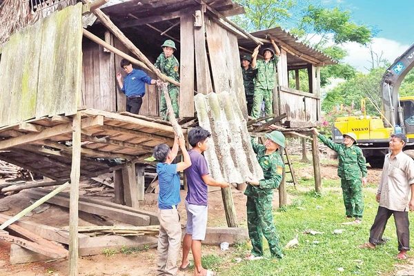 Bộ đội Biên phòng cùng thanh niên tình nguyện và các hộ dân ở xã biên giới Dân Hóa, huyện Minh Hóa tháo dỡ các mái nhà dột nát để làm nhà mới.