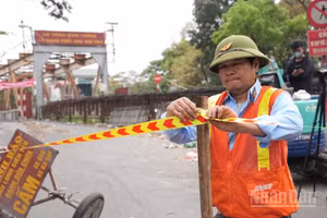 Biển báo và rào chắn được đặt tại các lối lên cầu Long Biên nhằm ngăn phương tiện lưu thông trong thời gian thi công. (Ảnh: HỒNG QUÂN)