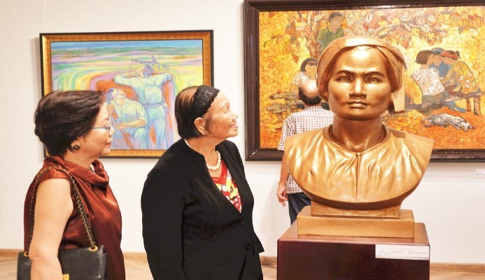 Các họa sĩ, du khách tham quan triển lãm mỹ thuật "Kể chuyện sau ngày thống nhất" tại Bảo tàng Mỹ thuật Thành phố Hồ Chí Minh. (Ảnh MẠNH HẢO)