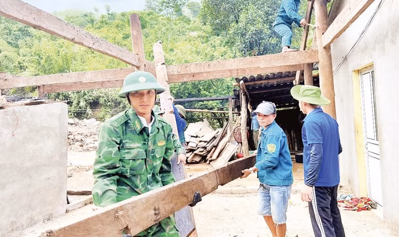 Cán bộ, chiến sĩ Đồn Biên phòng Nhôn Mai phối hợp các lực lượng di dời nhà dân bị ảnh hưởng do lũ quét.